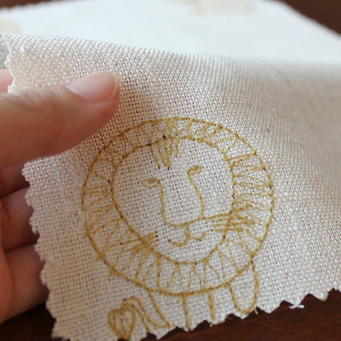 麻素材を織り込んだナチュラルな生地にイエローのライオンを刺繍