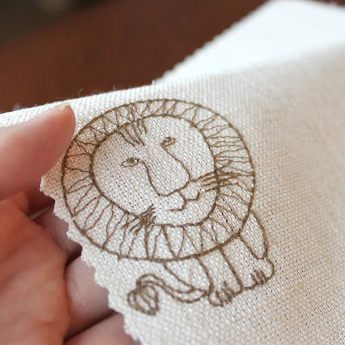 麻素材を織り込んだナチュラルな生地にイエローのライオンを刺繍